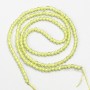 Small synthetic spinel beads, lime yellow, faceted round, 2 mm diameter (±), on a 37 cm strand