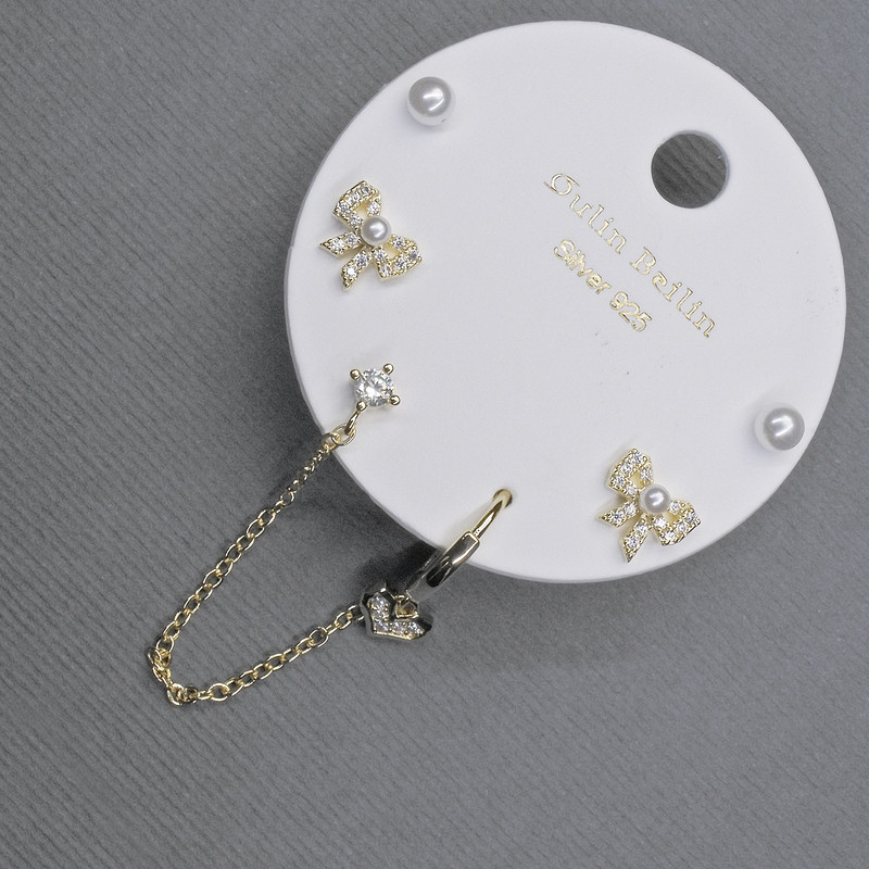 Gold-tone stud earrings with ear cuff and white crystals