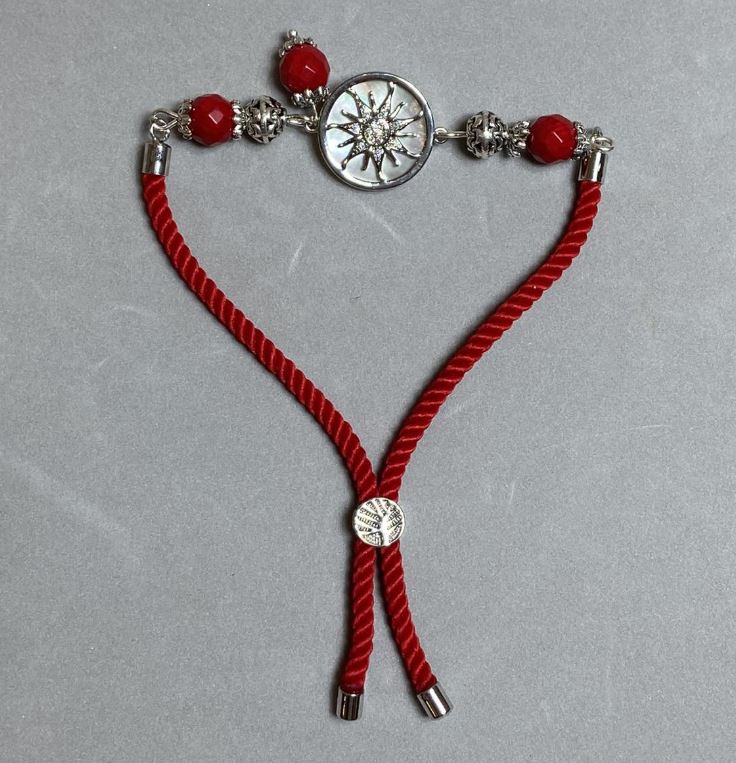 Textile bracelet, 5.5 mm diameter ±, adjustable; coral faceted bead 8 mm ±, with metal insert, 17 mm diameter ±, silver-colored metal