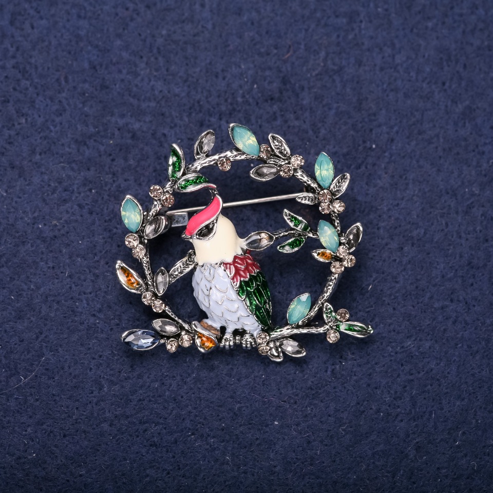 Brooch 'Bird on a Branch' with crystals and enamel, colors red, white, blue, green; 38x40 mm; silver-toned metal