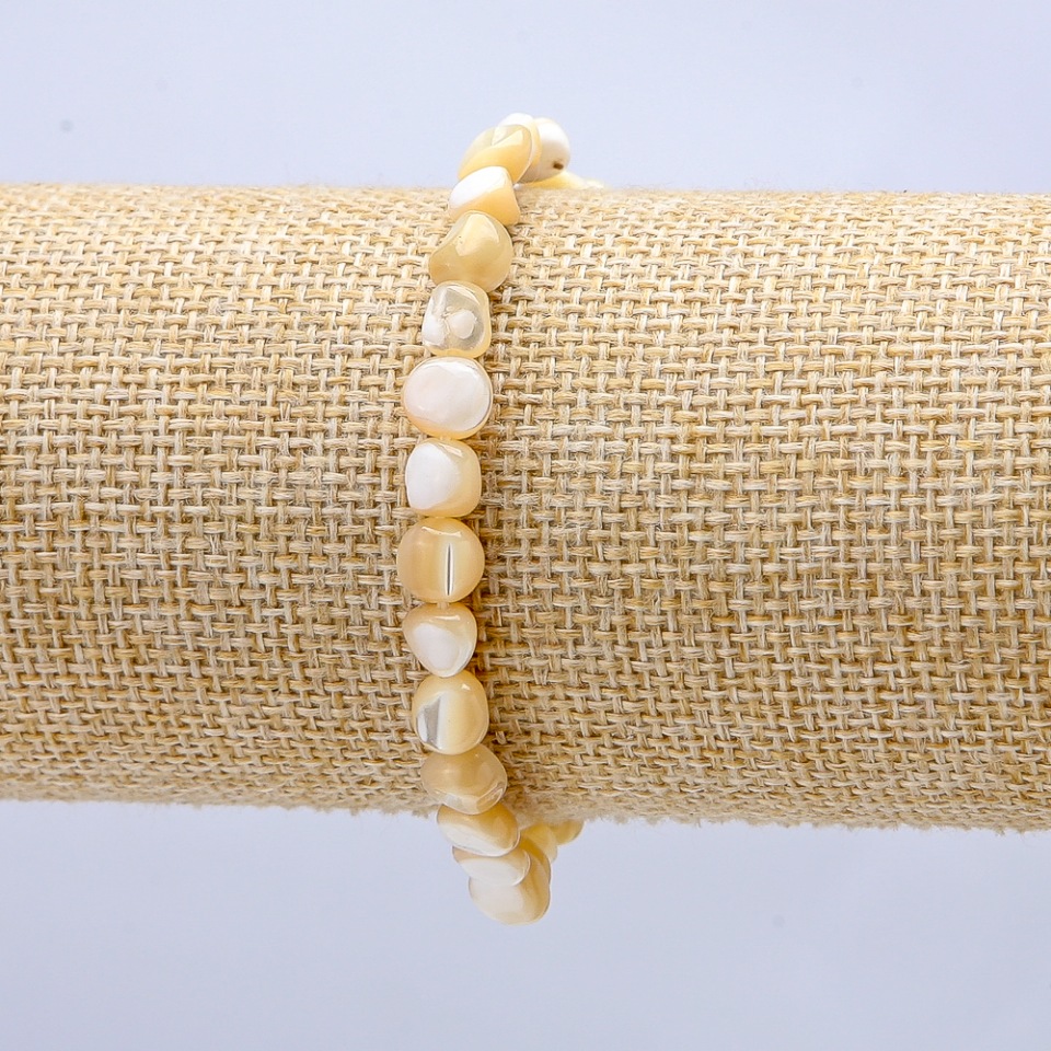 Elastic bracelet with natural beige mother-of-pearl. round beads, diameter 7×5 mm