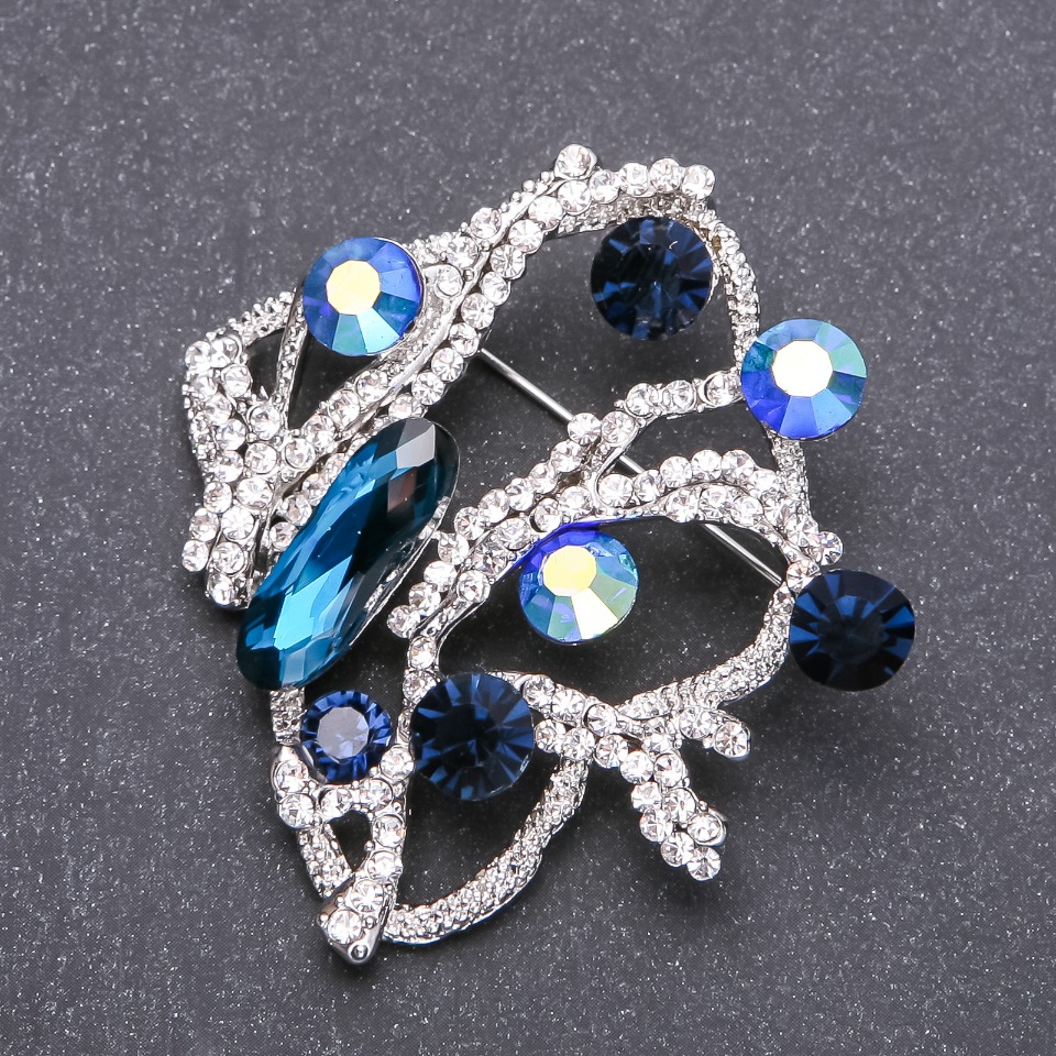 Brooch with blue crystals in white rhinestones, 56x53 mm, white metal